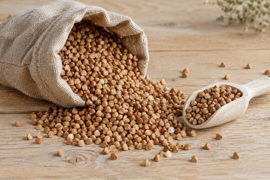 Raw buckwheat groats spilling from linen sack