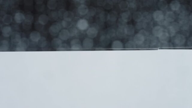 Rain drop hitting window glass and sliding down