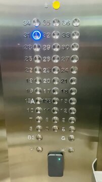 Elevator control panel in Vietnam with number 31 glowing blue and modified floor numbers 15A and 15B skipping unlucky numbers 4, 13, 14