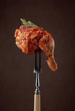 Chicken drumstick on a fork.
