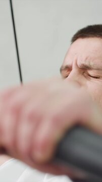 Close up of man neck jawline ear hair mouth area during intense workout. Visible skin texture details including pores on forehead or cheek slight redness from physical activity white tank