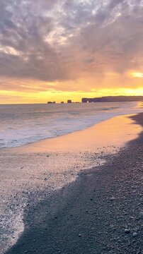 Dramatic Sunset Over Black Sand Beach and Ocean Waves in Iceland