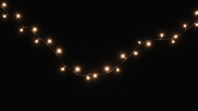 Strand of warm white Christmas string lights isolated on black background
