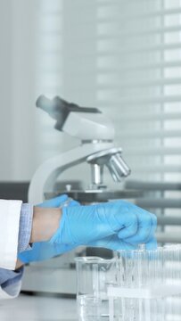 Woman scientist in protective gear performing a biological experiment in a modern laboratory, researching biotechnology and genetic engineering for health and medical advancements