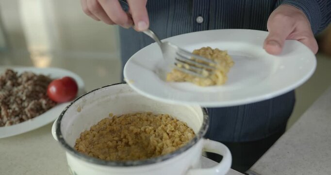 Close-up male hand put lentils on plate dish. 4K 10-bit