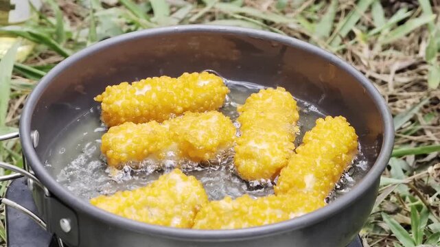 Deep frying crispy nuggets in hot oil outdoor camping pan