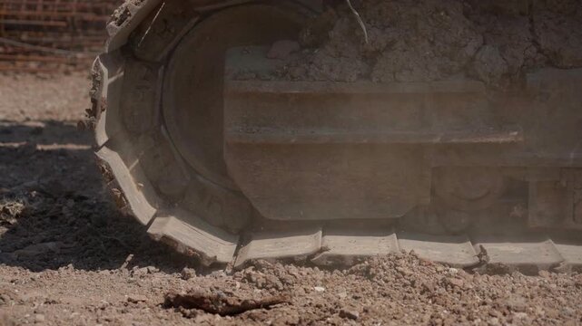 Excavator Crawler Tracks Moving Through Dirt at Construction Site