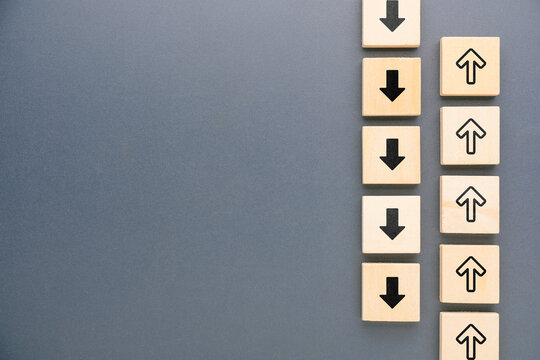 Up and down arrows moving in opposite directions, representing rising and falling trends, contrasting movement, change, different paths and opposing directions with copy space