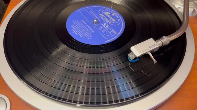 回転する黒いアナログレコード盤とターンテーブルのトーンアーム