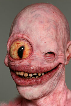 horror portrait mutant cyclops, grinning pink cyclops with huge orange slit pupil eye and long row of small teeth, photorealistic