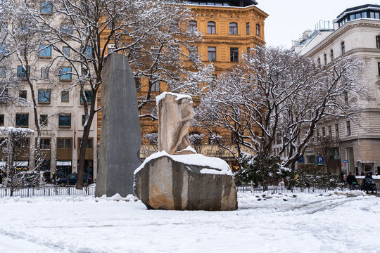 Vienna, Austria - circa Feb 2026: Snow covered stone monument at Albertinaplatz in Vienna, part of the Monument against War and Fascism by Alfred Hrdlicka with a granite stele and carved figure, fros