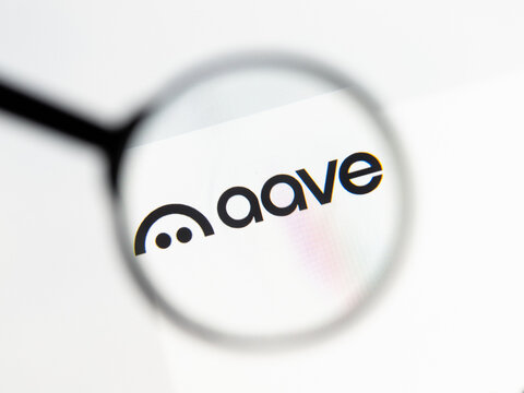 Milan, Italy 2026, 15 AGO Closeup of aave com website page on a laptop screen. Focus on aave com logo under a magnifying glass.