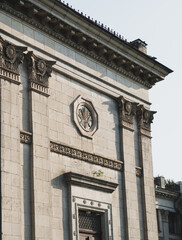 Low angle view of a historic neoclassical building facade featuring ornate stone columns, decorative cornice, and octagonal corn relief medallion © Вита Курило