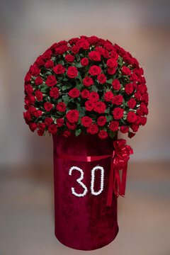 Impressive floral photo zone setup for 30th birthday anniversary celebration.Large luxurious red rose floral arrangement with number 30 stand in event hall.