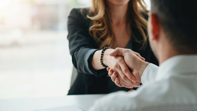 Professional business handshake between a man and a woman in an office setting