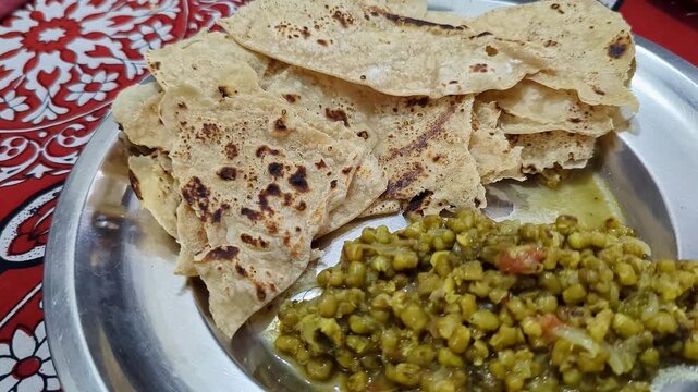 Closeup of warm soft rotis or flat bread served with nutritious sprouted moong on plate