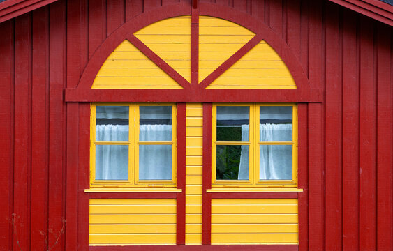 Title:
Traditional red and yellow wooden house facade with windows in Norway