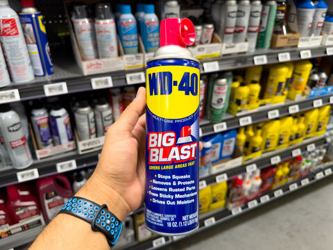 Frisco, Texas, USA - September 15th, 2026: Person holding blue WD-40 Big Blast multi-use product aerosol spray can inside retail store