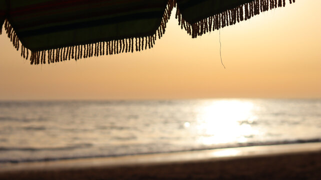 Beach umbrella fringe against sunlit ocean with copy space