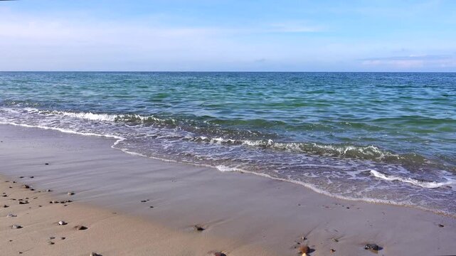 4k static video of a beautiful sandy beach with small ocean waves crashing on the shore, 1-minute seamless loop, with authentic sea sounds