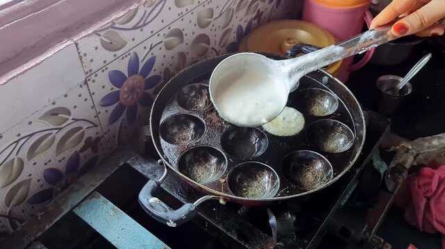 View of pouring batter into traditional appe pan for delicious south indian kuzhi paniyaram