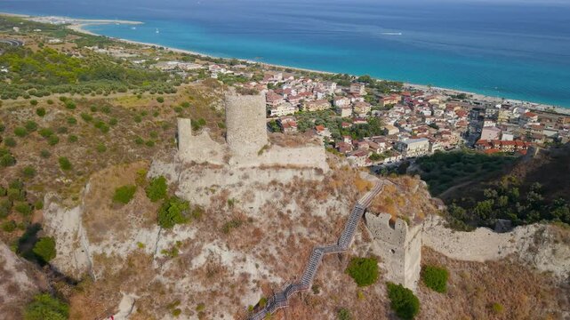 Roccella Ionica Calabria Italy Castello Carafa tower semi orbit drone reveal narrow rock cliff castle coastline turquoise Ionian sea travel 4k video