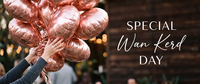 Rose gold foil birthday balloons held by hand for special wan kerd day celebration background with metallic party decorations rustic wood texture warm bokeh lights festive anniversary event banner