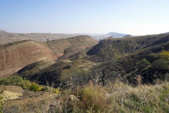 Layered geological hills and rugged ravines stretch across the colorful semi-desert badlands near Udabno and the Davit Gareja region in eastern Georgia