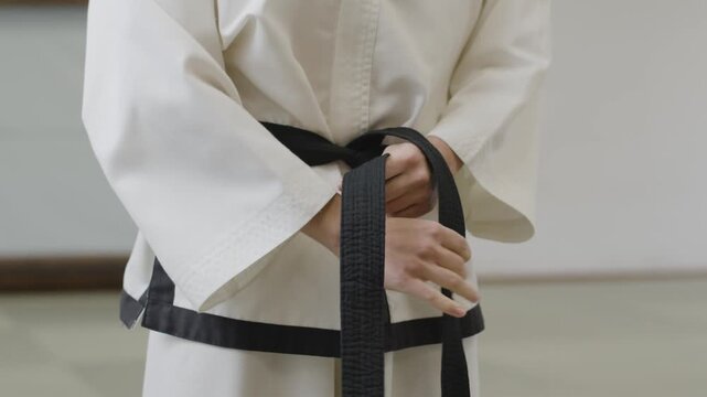 karate man in kimono. Taekwondo Sport. uniform taekwondo holding black belt in own hand while standing over isolated white background. Activity power tradition Korean concept.