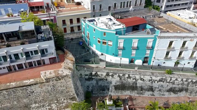 Drone side pan of the colorful buildings in old San Juan next to Paseo la Princesa. 