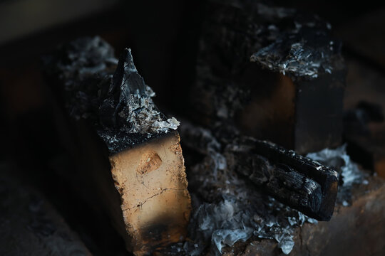 Burned Wood Logs in Fireplace with Ashes and Charred Remains of Fire