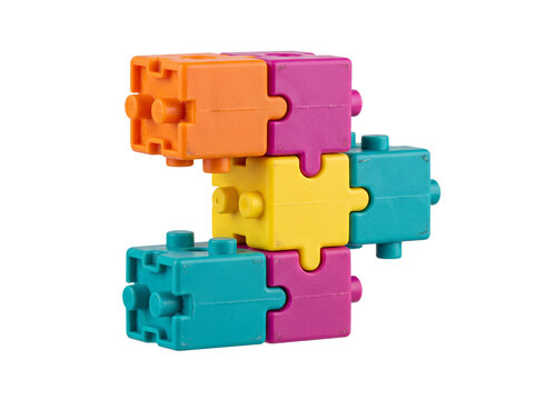 Colorful plastic puzzle building blocks interconnected together on a black background representing teamwork, synergy, and creative construction for children's educational toy concept design and values
