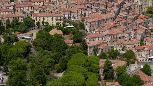 Morano Calabro Calabria Italy 4k drone view of Swabian castle on hilltop. Vertical tilt up from monastery across dense medieval village terracotta roofs 70mm telephoto broll establishing video