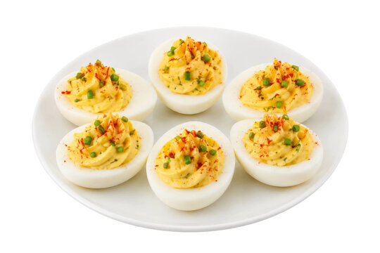 Six classic deviled eggs garnished with paprika and fresh chives on a clean white plate
