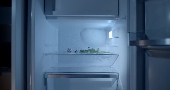 Cinematic slider push-in toward an empty opened refrigerator, emphasizing the lack of food and household essentials. Powerful visual concept for poverty, hunger, food insecurity, financial hardship.