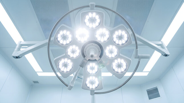 A close-up view of a modern surgical LED light fixture in a hospital operating room. The bright, sterile lighting is designed for high-precision medical procedures, ensuring optimal visibility for...