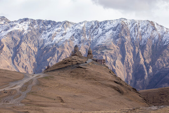 Gergeti Trinity Church in Kazbegi Georgia Against Snow Covered Caucasus Mountain