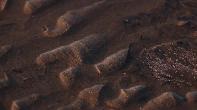 Magical natural patterns formed by sand on multicolored Hormuz Island beach, Iran. mineral sands including hematite, ilmenite, and magnetite create striking textures shorelineIn the Persian Gulf..