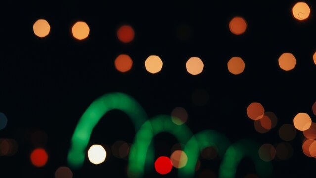Abstract out of focus night bokeh lights effect with warm yellow circles and green neon wave shapes