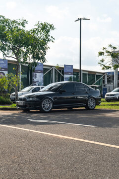 Black BMW 3 Series E46 Luxury Sedan Side Profile View Parked at Outdoor Asphalt Parking Lot Near Modern Building