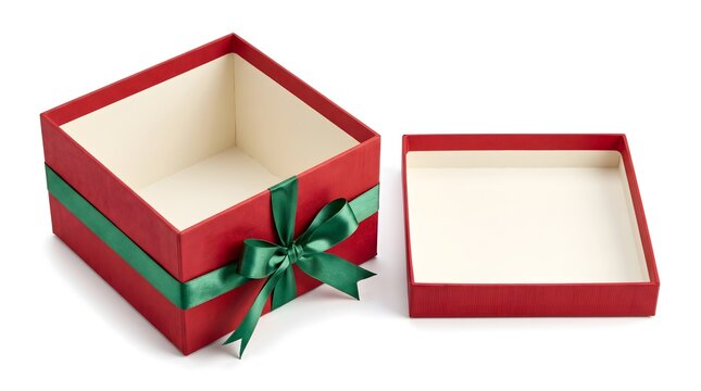 An open red gift box with green ribbon next to christmas socks and a christmas candy stick