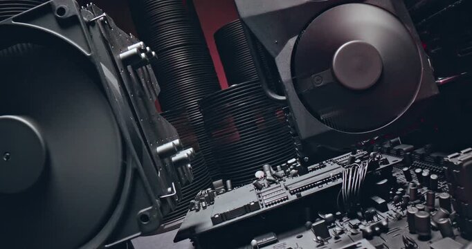 Motherboards graphics cards and cooling fans. Camera pans across hardware.