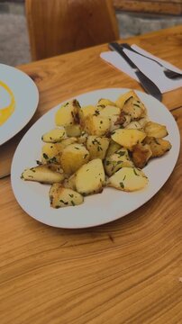 Plate of Roasted Potatoes Served on Table