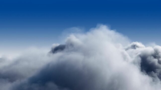 Dense white clouds billow and shift across deep blue sky as sunlit rounded tops rise above darker shadowed layers, filling broad frame with changing atmospheric forms in daylight