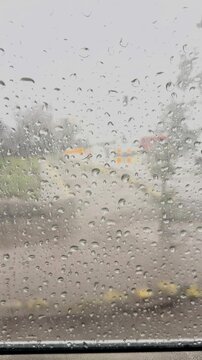 Rain drops on window with blurred urban background