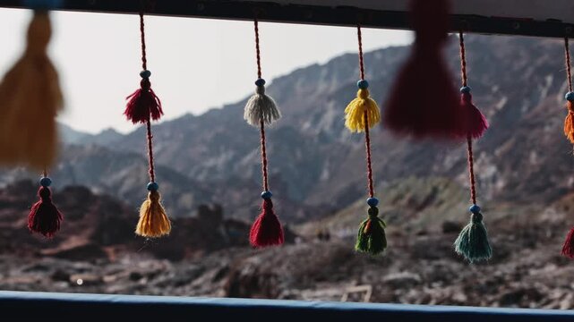 Colorful decorative yarn tassels hanging and gently swaying, traditional oriental tribal handmade hanging ornaments, Traditional Persian decoration used in transportation and interior design.