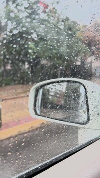 Heavy rain on vehicle window in urban area