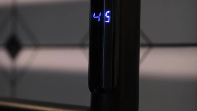 finger taping sensor button changing temperature of electric heater in the bathroom