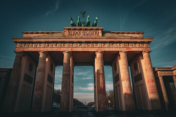 A dramatic low-angle shot of the Brandenburg Gate under a twilight sky. © Leo