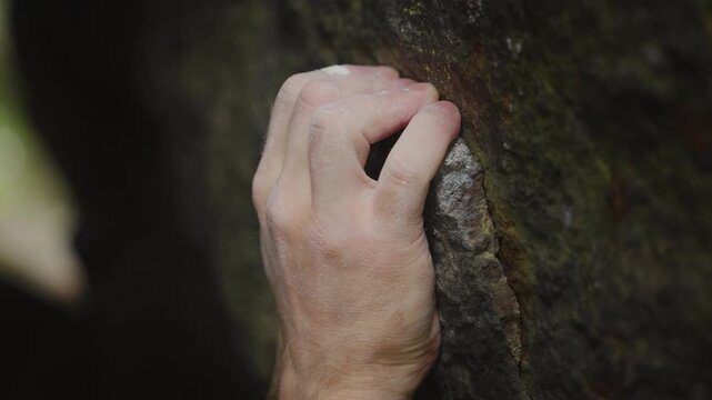 Close Up of Rock Climber Gripping Small Crimp Hold on Boulder